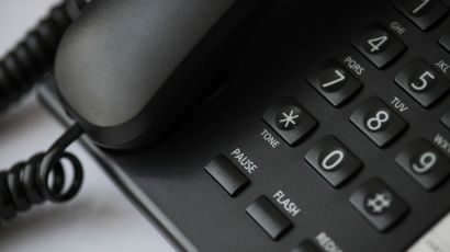 Close-up of a black wired office desk telephone with keypad and handset.